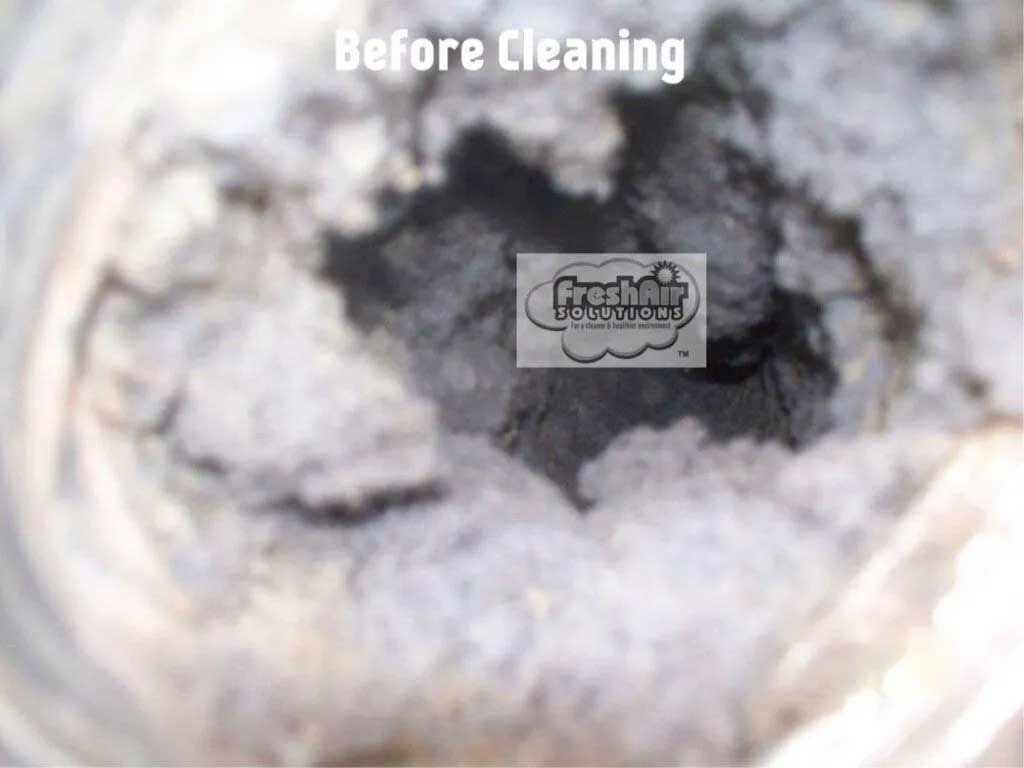 Dirty air duct interior before cleaning, filled with thick layers of dust and debris.