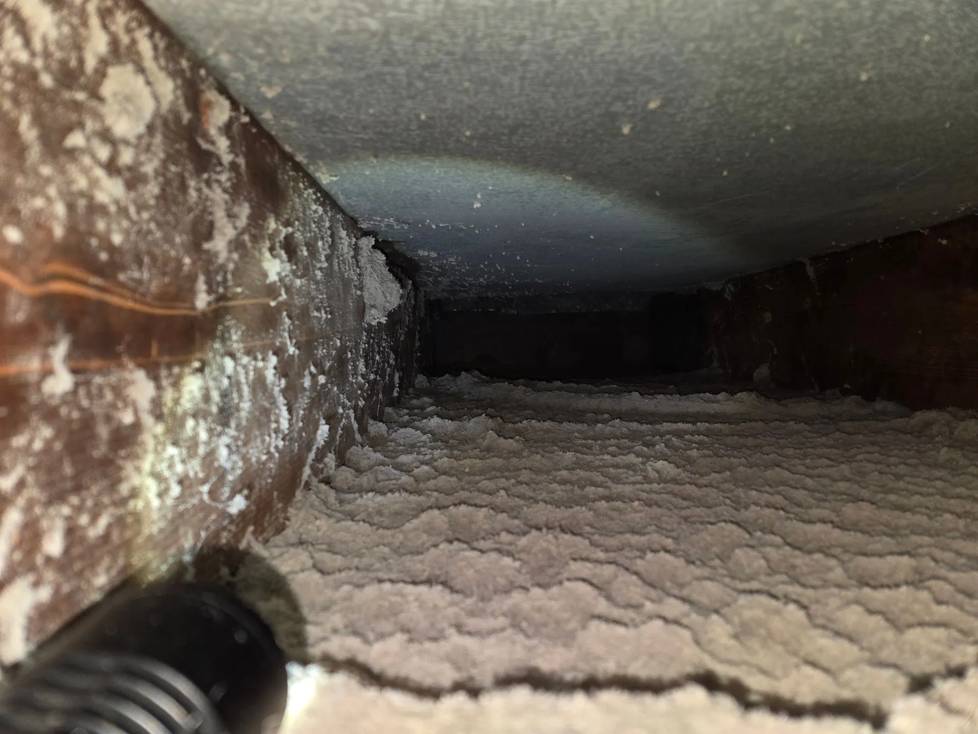 Air duct interior showing debris buildup before cleaning